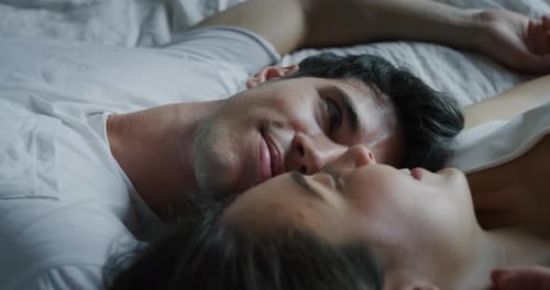 Cinematic close up shot of young couple in love is relaxing in the bedroom in the early morning in