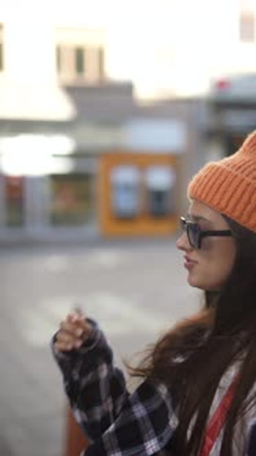 Stylish Woman in City Wearing Knit Hat and Sunglasses