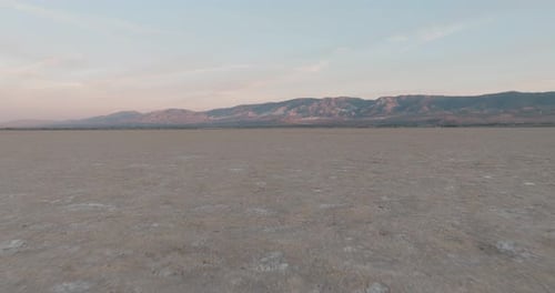 a large flat area with mountains in the background