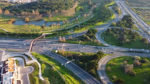 Drone shot showing a massive highway right next to a big city park.