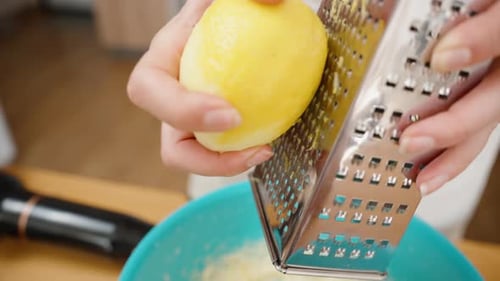 Lemon Zest Falling into Turquoise Bowl with Batter