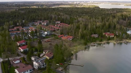 A beautiful town is viewed from an aerial perspective next to a river with its docks and cottages se