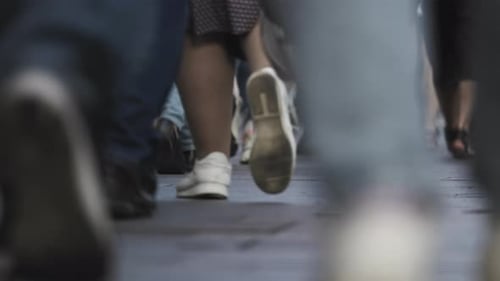 crowd of people, pedestrians, walking down the street of the city, feet