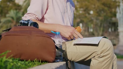 Young Man Office Worker Having Lunch Outdoors Drinking Coffee and Eating Sandwich While Sitting on
