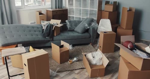 Room full of unpacked moving boxes and furniture