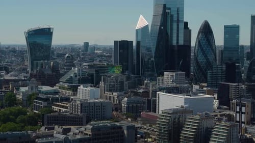Ascending drone shot of Central London Financial district skyline under the blue summer sky.
