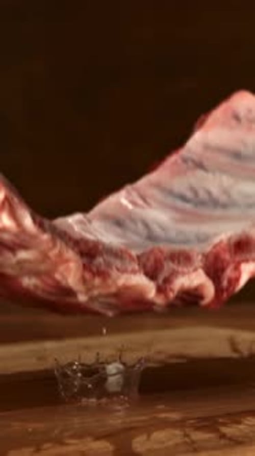 Raw Pork Ribs Fall Onto a Cutting Board Filmed on a Highspeed Camera at 1000 Fps