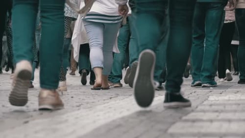 Füße von Menschenmengen, die in Zeitlupe auf der Straße laufen