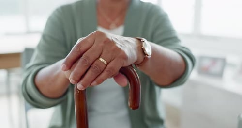Hands, walking stick and senior woman with a disability at nursing home for elderly care
