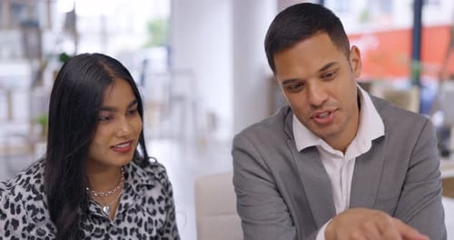 Coworkers Collaborating on a Laptop in Modern Office