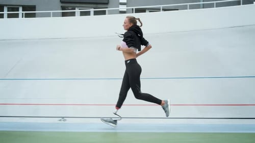 Side View Jogger with Artificial Limb Training on Running Surface at Stadium