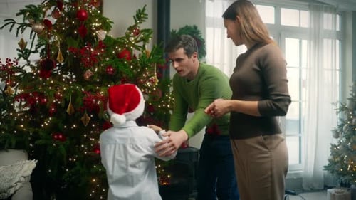 Family Decorates Christmas Tree Together at Home