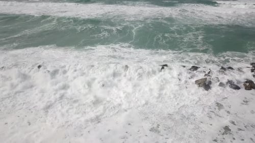 Waves Crashing on Rocky Shoreline Aerial View
