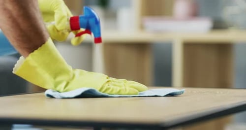 Man Wearing Gloves Cleaning Table Surface
