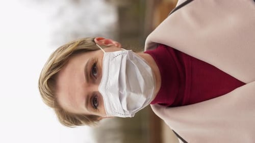 Woman Wearing Mask Looking Downward Outdoors Vertical