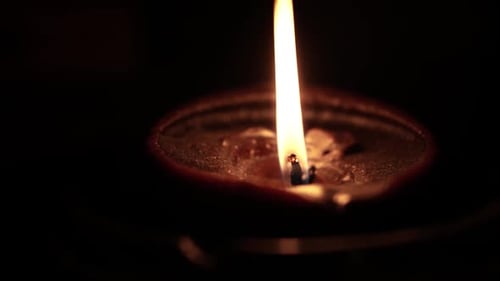 Glowing Diwali Diya Lamp Flame in Darkness