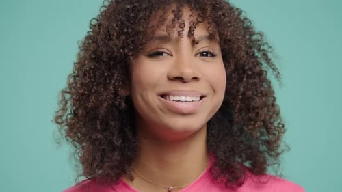 Smiling Woman with Curly Hair Wink and Laughs