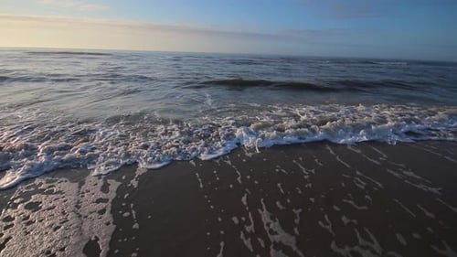 Wave crashing and moving up on beach shore. Water rushing up beach. Water moving up the shoreline. S