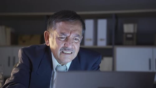 Frustrated Man Working Late at Computer