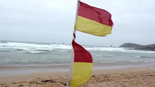 Warning flag in wind at Constantine beach, Cornwall,UK.