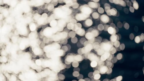 Sunlight Dances Across Deep Blue Ocean Ripples Shifting From Soft Defocused Bokeh to Crisp Sparkling