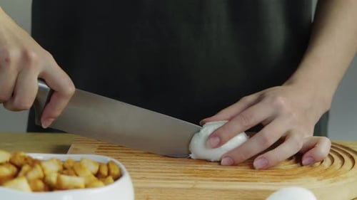 Adult Slicing an Egg on Wooden Cutting Board