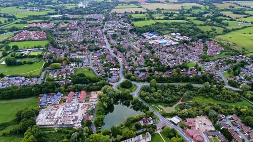 aerial high angle drone shot moving towards Bishops Waltham, England village town at autumn sunset