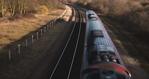 Tren pequeño de pasajeros que pasa por debajo de una pasarela