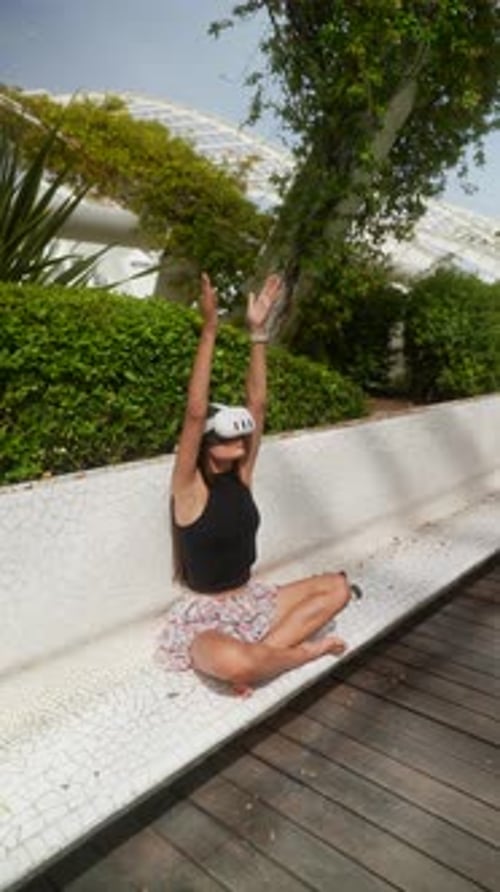 A Woman is Immersed in Virtual Reality Using a Headset in a Peaceful Outdoor Park Setting