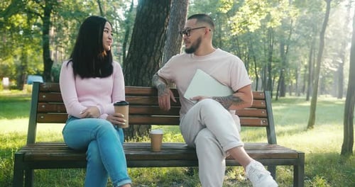 Asian Man and Woman Discuss Life Issues in Morning Park