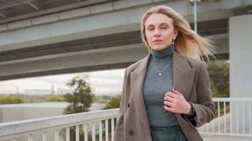 Stylish Blonde Business Woman in Long Coat Walking in City on Autumn Day