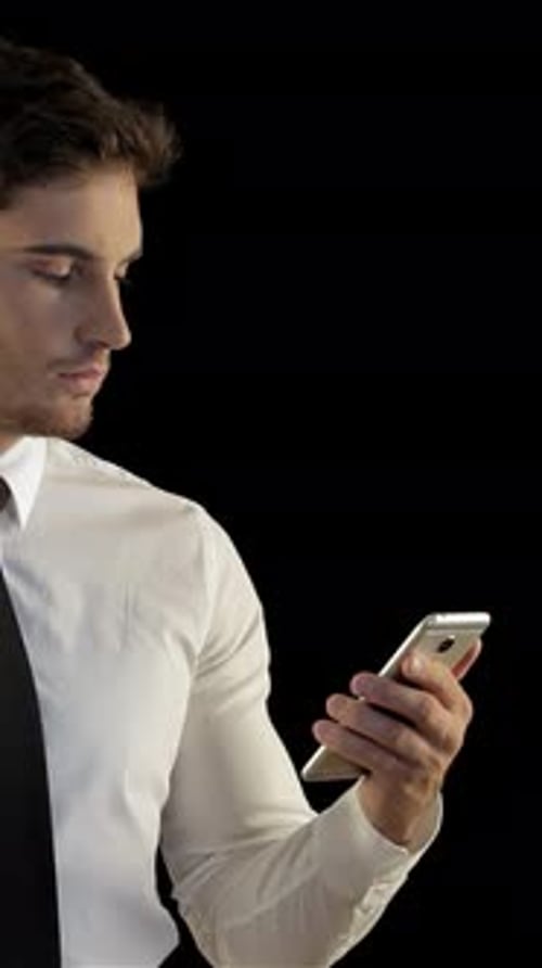 Focused Man in a Sleek Suit Checks Smartphone with Confidence
