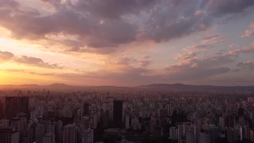 sunset big city São Paulo drone up to the buildings pan