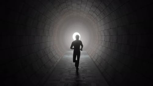 Man running in the tunnel towards the light