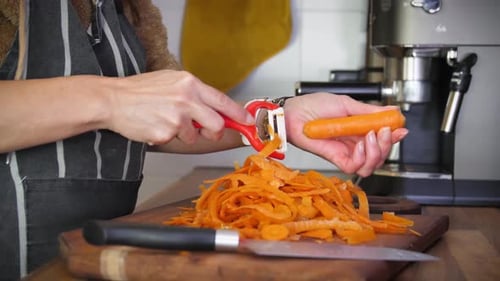 Woman Shredding Carrots in Kitchen Preparation
