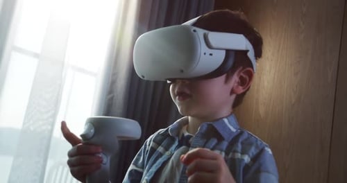 Boy Plays Virtual Reality Game with Headset