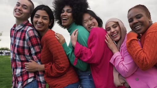 Happy young multi ethnic women having fun together in a public park