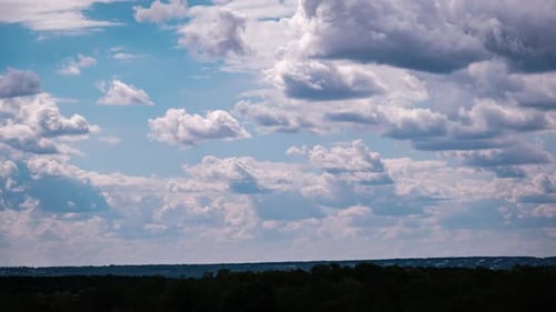 Clouds Time-Lapse Above Dark Green Treeline
