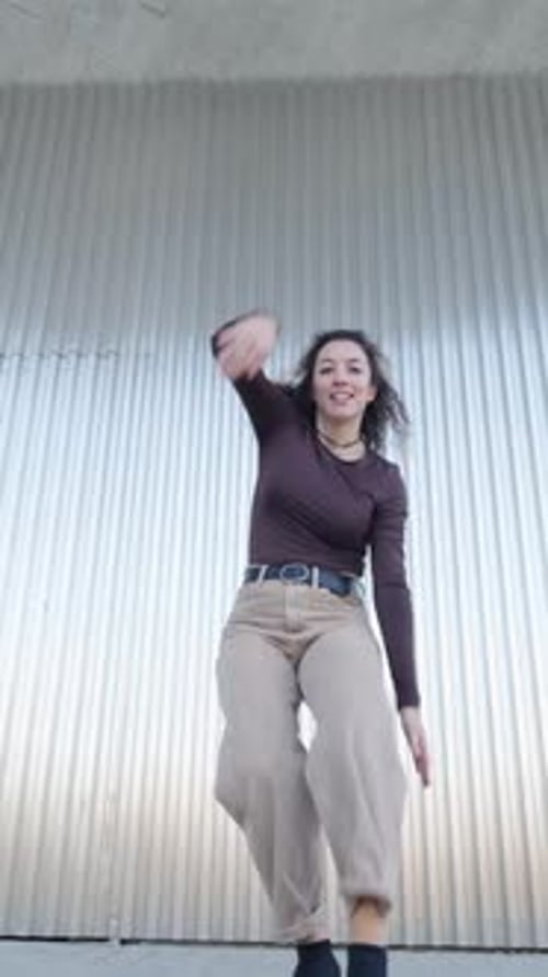 Stylish Woman Dancing in Urban Setting