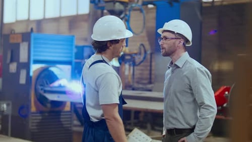 Factory Worker Shaking Hands and Discussing Tasks with Engineer