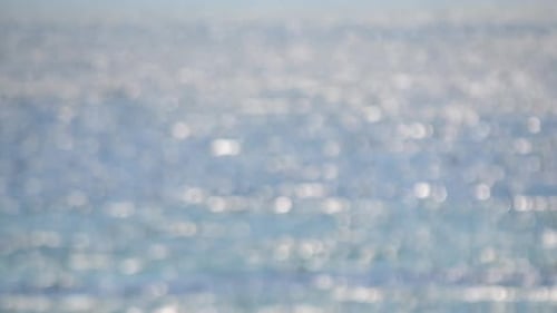 Blurred Background Blue Sea White Bokeh Spots of Ripples on Water of Sun Glare