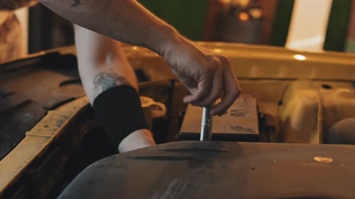 Close Up Of Tattooed Mechanic Hands Fixing Car Engine With Wrench