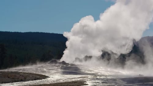 Dampf füllt die Luft hoch über dem Yellowstone-Geysir, Morgenlicht scheint durch