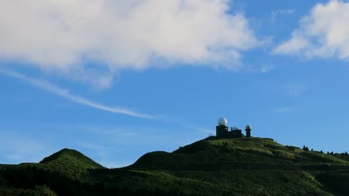 Clear Skies: Mountain Summit's Serene Blue Sky and Dynamic White Clouds.