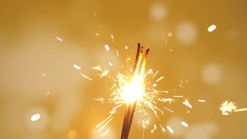 Sparkling Sparklers Against Yellow Background Sparking Brightly