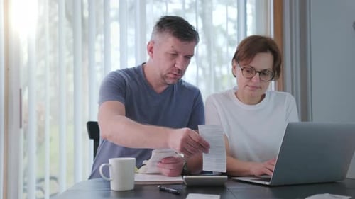 Woman and Man Together Checking Bills Taxes Bank Account Balance and Calculating Expenses in the