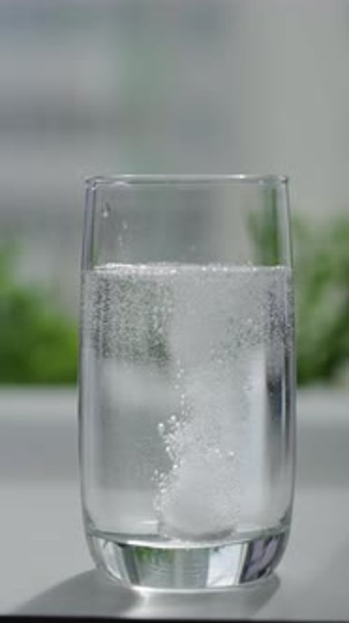 Effervescent Tablet Dissolving in Glass of Water