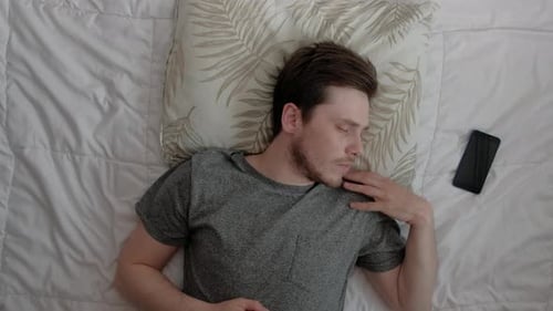 Young Man Sleeping in Bed, Wakes Briefly