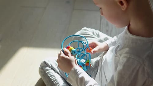 Little Boy Playing Education Logical Toy on the Floor in Nursery