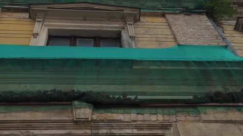 This Urban Buildings Facade Is Adorned with Green Netting and Rich Vegetation Growth Creating a